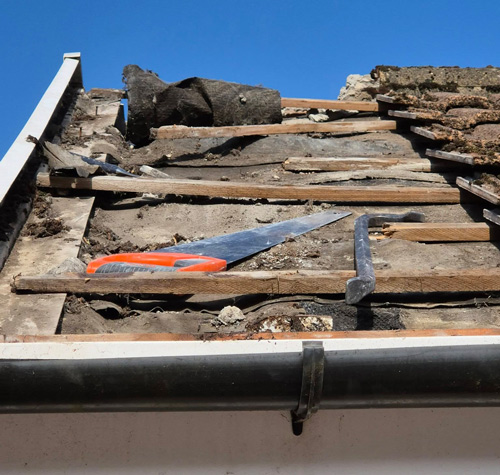 damaged roof shingles with tools and debris showing restoration process 3 steps repair