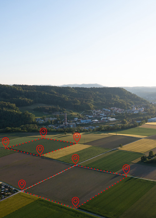 aerial view of agricultural fields with visible boundary markers and a small town in the background representing precision farming techniques for crop management and land use optimization 4 strategies for improvement