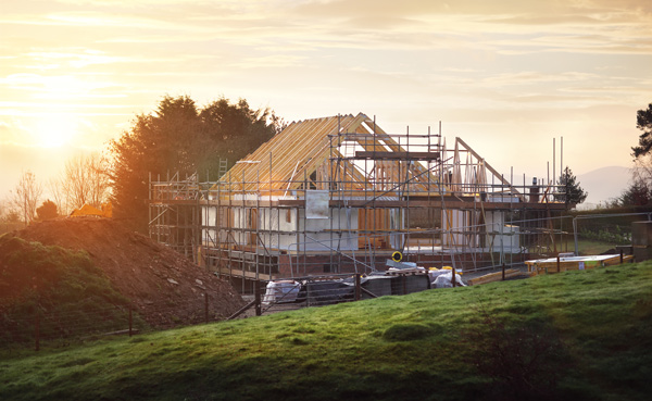 construction of a house with scaffolding at sunset featuring natural landscape and green grass area building project 2 construction stages