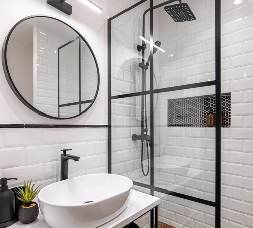 modern bathroom design featuring a glass shower sleek round mirror and stylish basin complementing minimalist aesthetics 2 contrasting colors 2 elegant fixtures