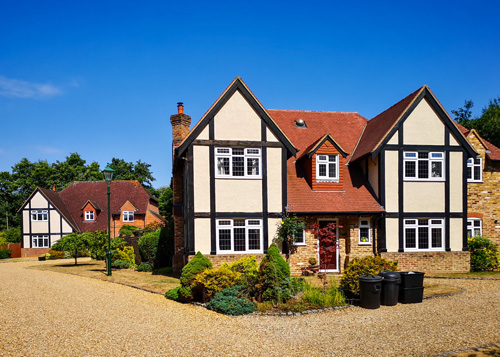 large suburban house with traditional architecture surrounded by greenery and parked cars showcasing stylish homes and lovely curb appeal