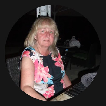 woman sitting at a table wearing a floral dress with brightly colored flowers enjoying a meal during the evening six dinner options
